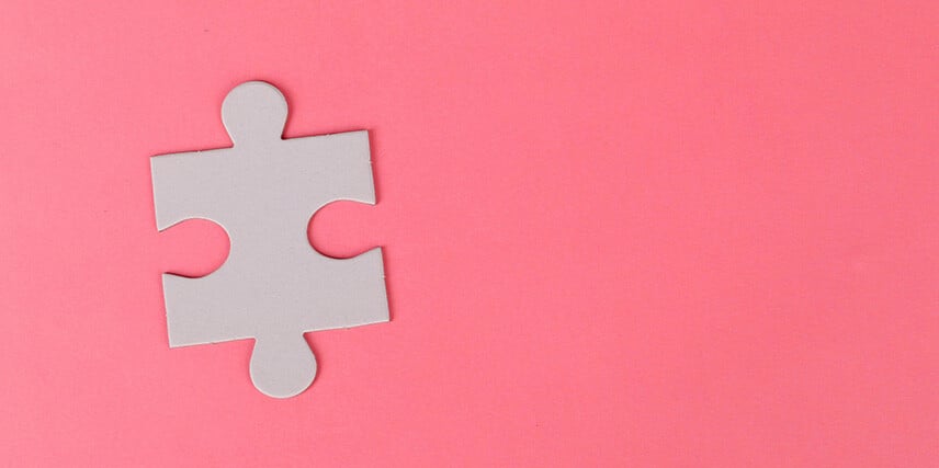 Single puzzle piece on pink background